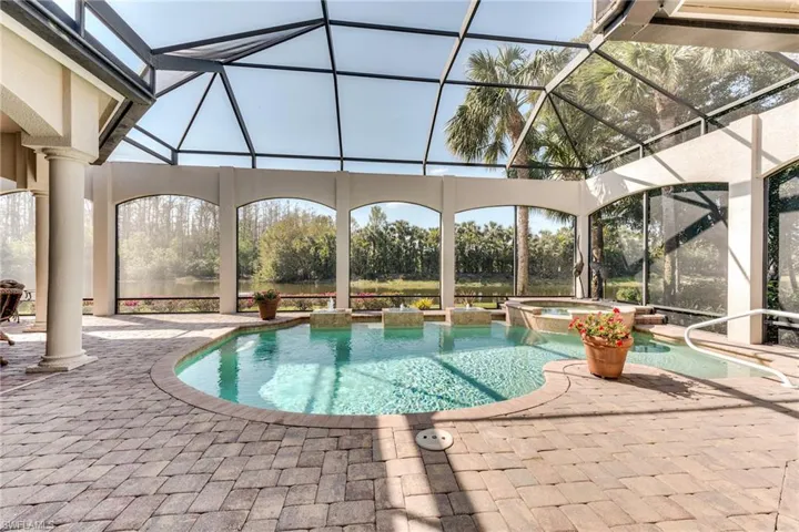 View of swimming pool featuring a patio area, a lanai, and a pool with connected hot tub