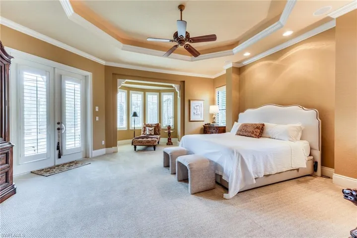 Bedroom with access to outside, carpet floors, a raised ceiling, and crown molding