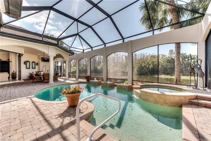 View of pool featuring a ceiling fan, a lanai, a patio area, a pool with connected hot tub, and outdoor lounge area