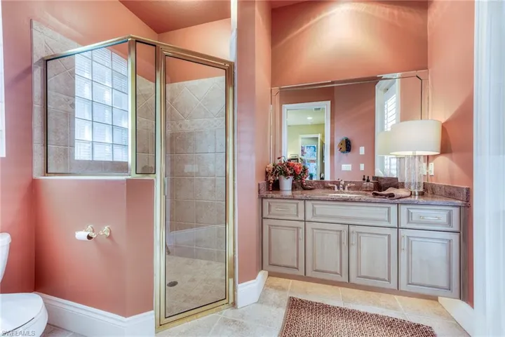 Bathroom with a stall shower, vanity, toilet, and tile patterned floors