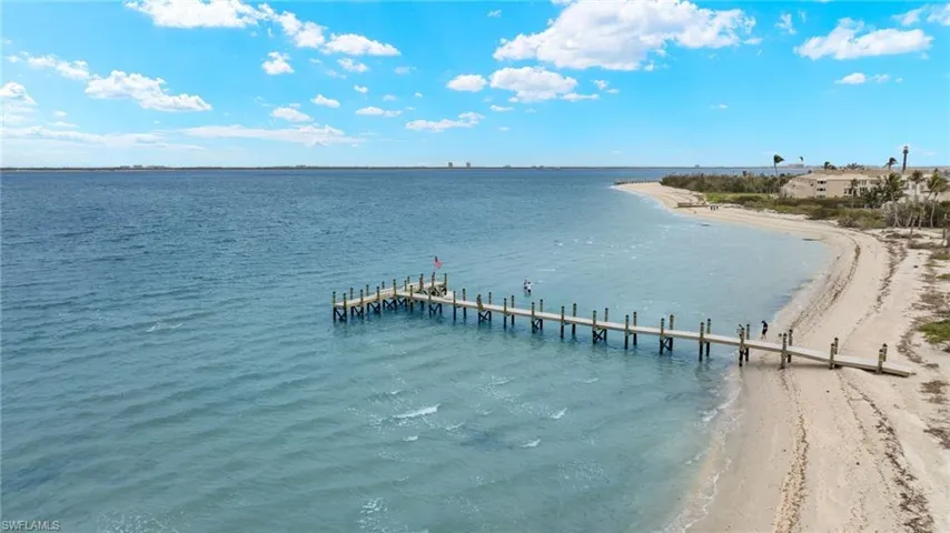 View of dock featuring a water view and a view of the beach