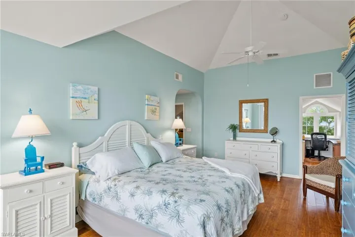 Bedroom with ceiling fan, dark hardwood / wood-style flooring, and lofted ceiling