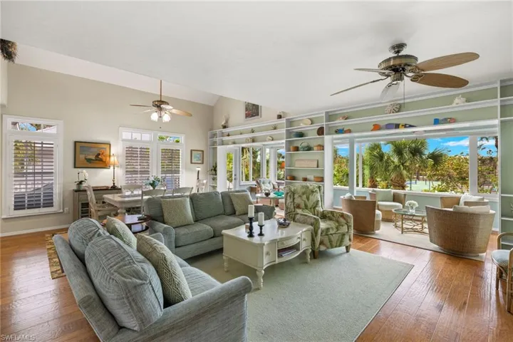 Living room with ceiling fan, hardwood / wood-style floors, plenty of natural light, and lofted ceiling