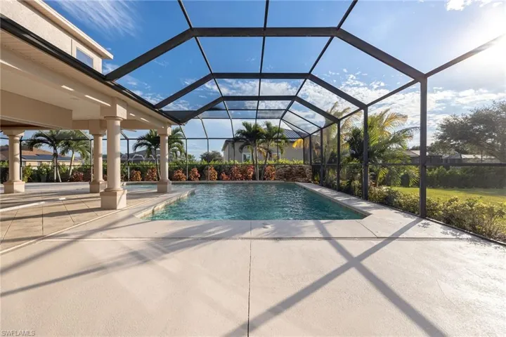 Swimming pool with glass enclosure, a sunroom, and a patio