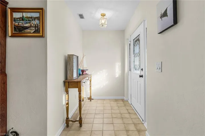 Foyer entrance featuring a textured wall and light tile flooring