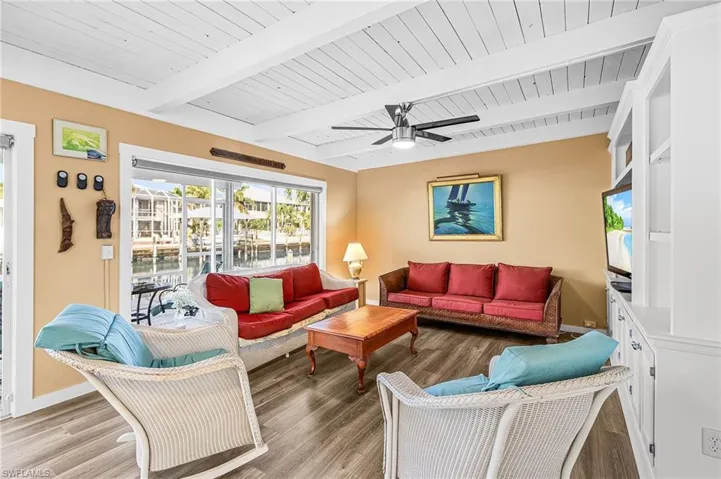 Family room featuring ceiling fan, a wood ceiling with exposed beams, and LVP floors