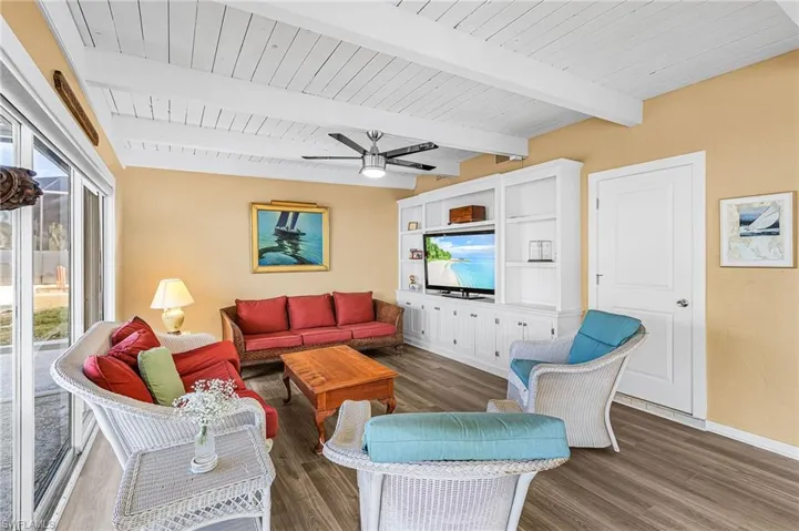 Family room featuring LVP floors, a ceiling fan, and a wood ceiling with exposed beams