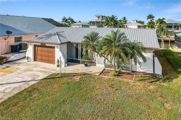 View of front of property featuring stucco siding, an attached garage, and a front yard