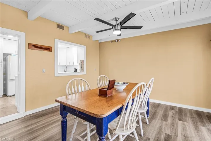 Dining space featuring ceiling fan, a wood ceiling with exposed beams, and LVP floors