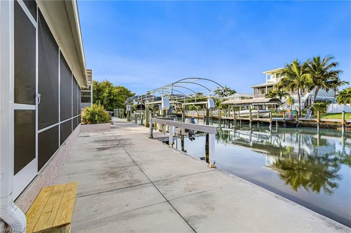 Dock area with boat lift, a water view, and a residential view