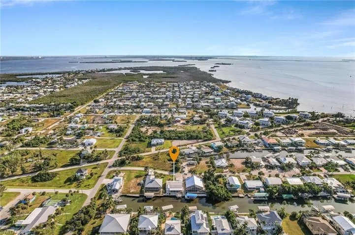 Aerial view of property and surrounding area featuring nearby suburban area and a nearby body of water