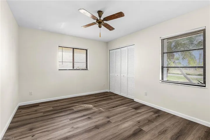 Unfurnished bedroom with dark wood-type flooring, a closet, and ceiling fan