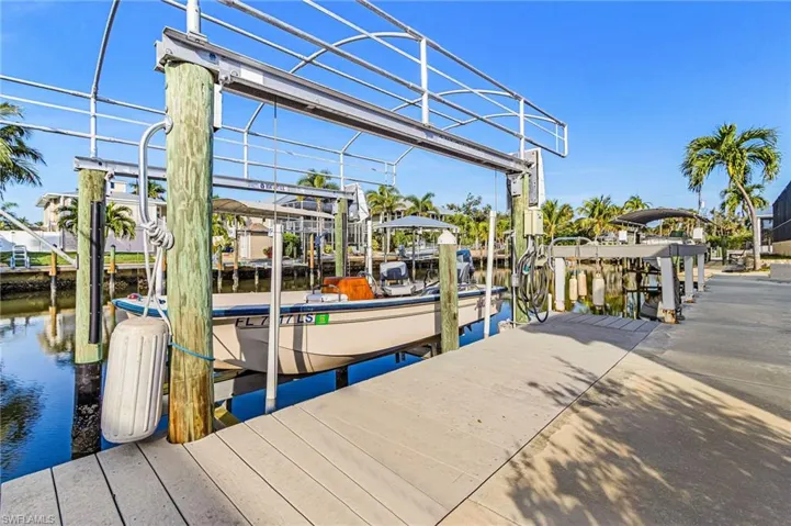 Dock area featuring boat lift and a water view