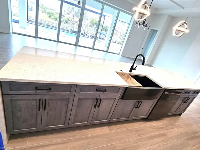 Center island with double waterfall quartz counter tops and farmers sink
