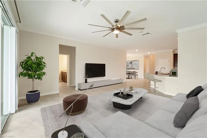 Virtually Staged Living room featuring crown molding high ceilings and ceiling fan.