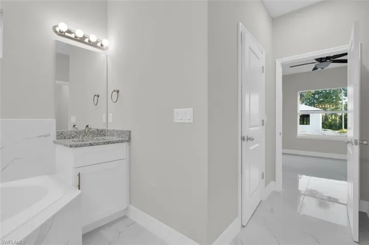 Bathroom vanity with a granite countertop, undermount sink, and brushed nickel faucet