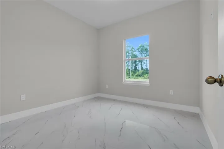 Bright interior space featuring light grey walls, white baseboards, and a single window with white trim