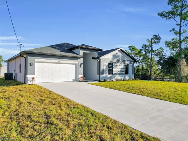 Contemporary single-story residence featuring a gray exterior with white trim, an attached garage, a concrete driveway, and a dark shingle roof