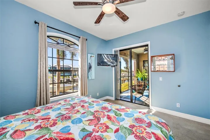 Unfurnished bedroom featuring carpet flooring, access to exterior, and ceiling fan