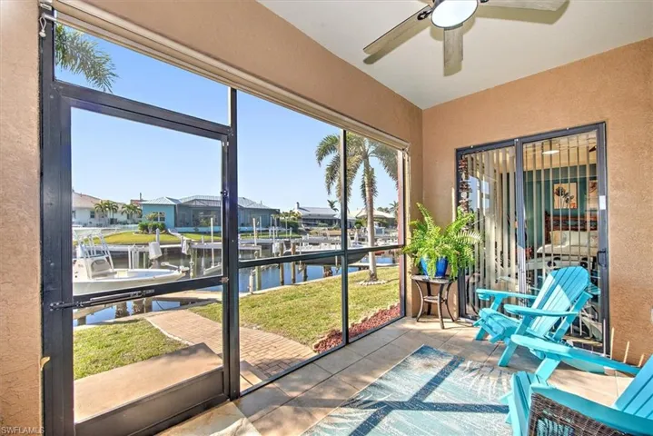 Sunroom with ceiling fan and a water view
