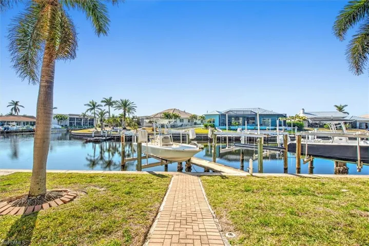 View of dock featuring a yard and a water view