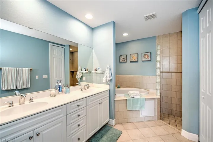 Bathroom with tile patterned flooring, plus walk in shower, and vanity