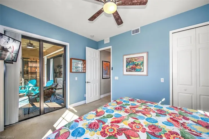 Carpeted bedroom featuring ceiling fan, access to outside, and a closet