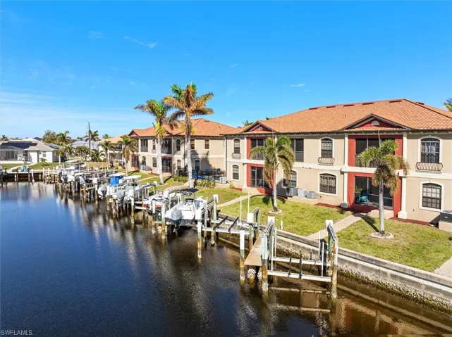 View of dock with a water view and a lawn