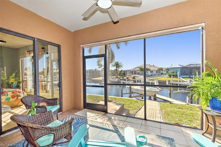 Sunroom / solarium with ceiling fan and a water view