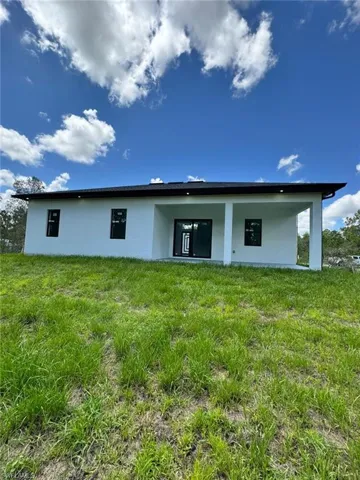 Back of property featuring stucco siding, a yard, and a patio