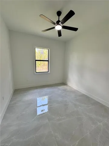 Unfurnished room with baseboards and ceiling fan
