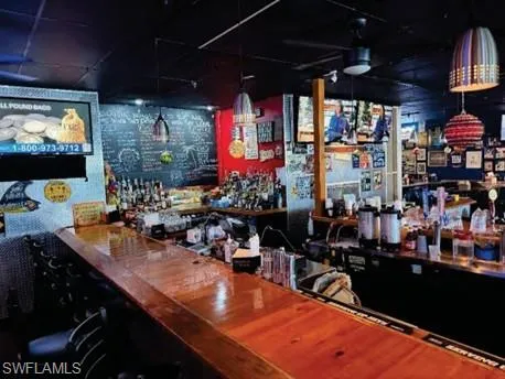 Community bar area with decorative light fixtures and butcher block counters