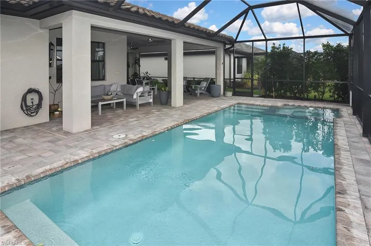 View of swimming pool featuring an outdoor living space, a lanai, ceiling fan, and a patio area
