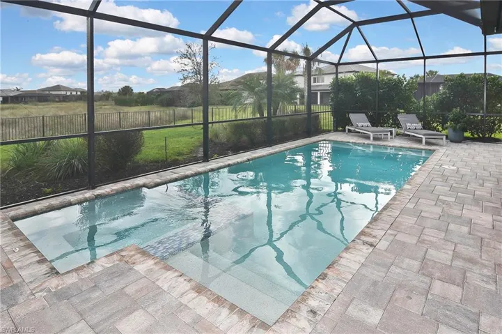 View of swimming pool with a patio and a lanai