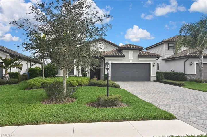 Mediterranean / spanish home with a garage and a front lawn
