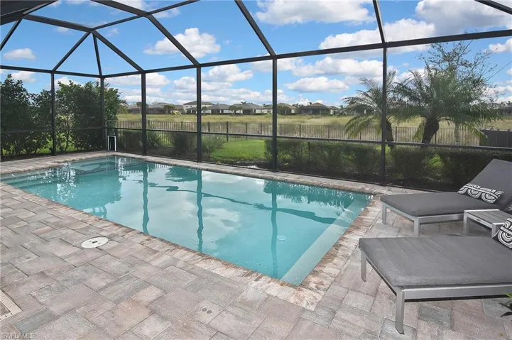 View of pool with a patio area and a lanai