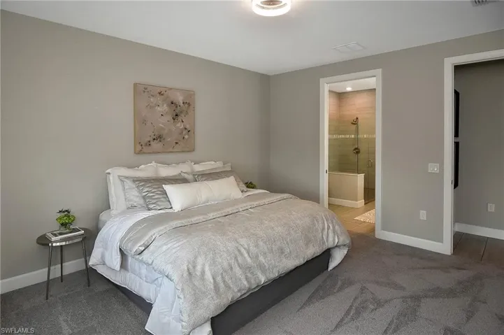 Carpeted bedroom featuring ensuite bath