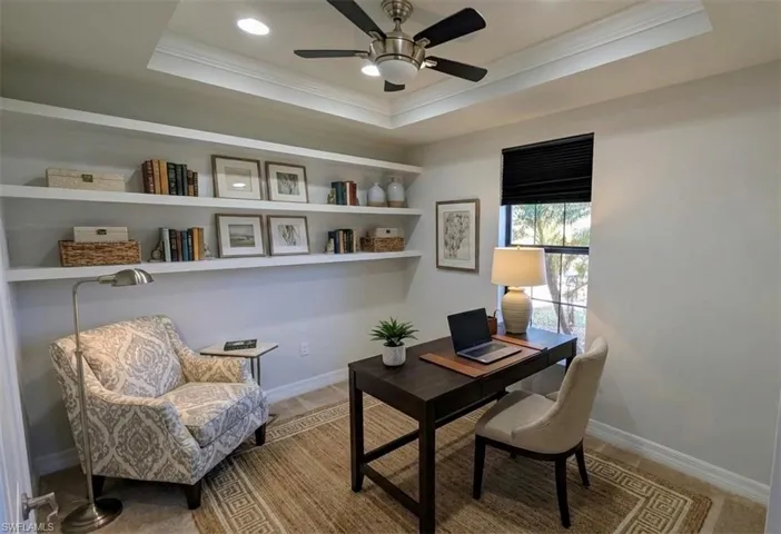 Office area with ornamental molding, ceiling fan, recessed lighting, and a tray ceiling