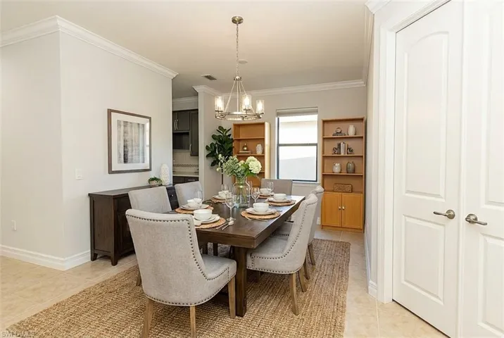 Dining space featuring crown molding, light tile patterned floors, and a chandelier