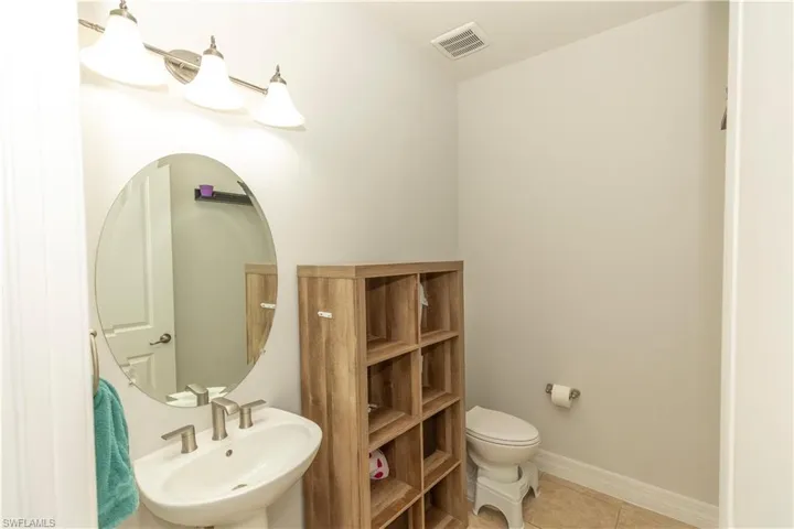 first floor Half bathroom with toilet and tile patterned floors