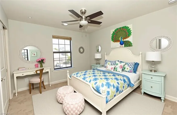 Bedroom featuring light carpet, an office area, a ceiling fan, and a closet