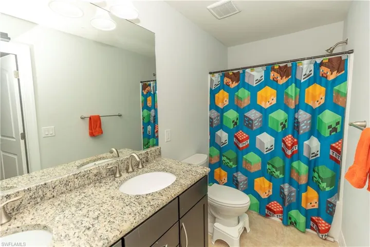 Full bath with double vanity and curtained shower