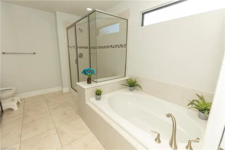 Full bathroom featuring a shower stall, a garden tub, light tile patterned floors, and recessed lighting