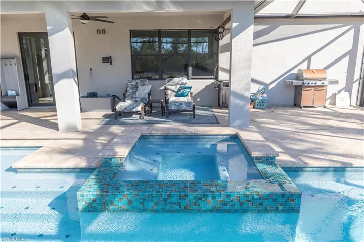Integrated pool / hot tub featuring a patio area and area for grilling