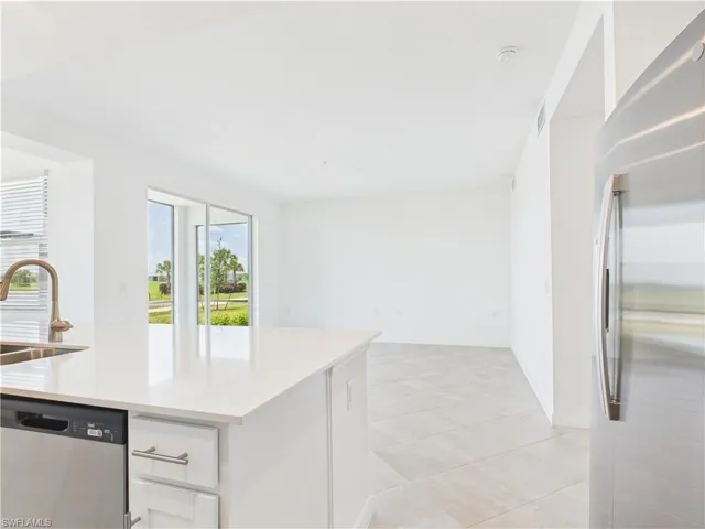 Kitchen with appliances with stainless steel finishes, white cabinets, light countertops, and light tile patterned flooring