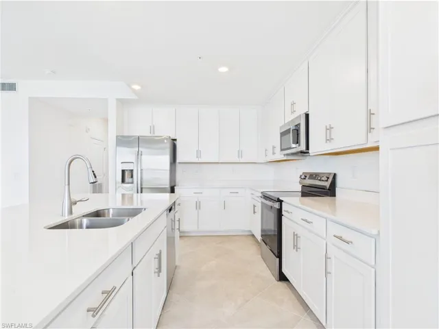 Kitchen featuring stainless steel appliances, light countertops, white cabinetry, recessed lighting, and light tile patterned flooring