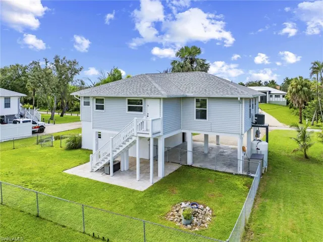 Back of house with a patio area, roof with shingles, stairway, and a fenced backyard