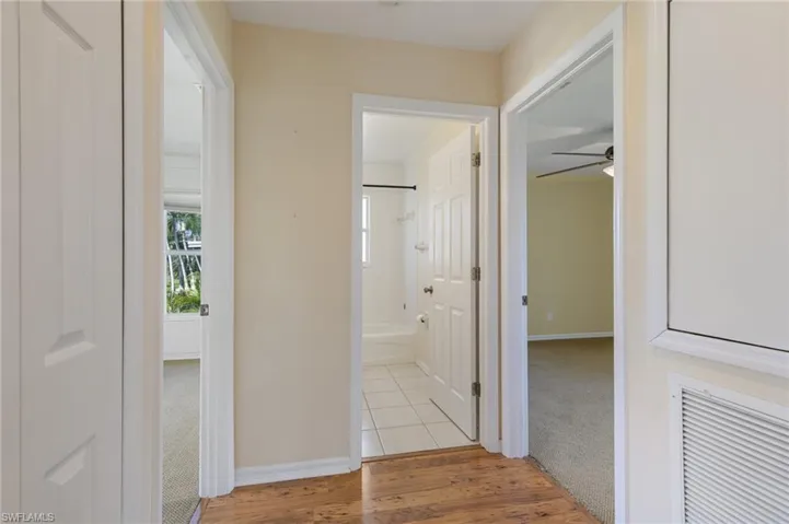 Corridor featuring light wood-style floors and light carpet