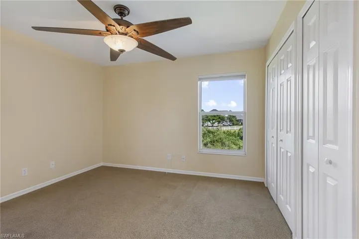 Unfurnished bedroom featuring multiple closets, carpet floors, and ceiling fan