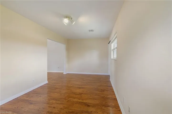 Unfurnished room featuring wood finished floors and baseboards